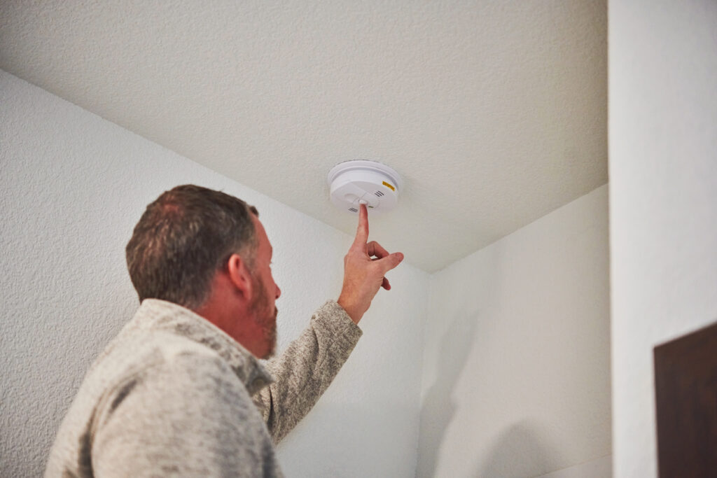 House inspection checking the smoke alarm to make sure it is still working while the owner is away